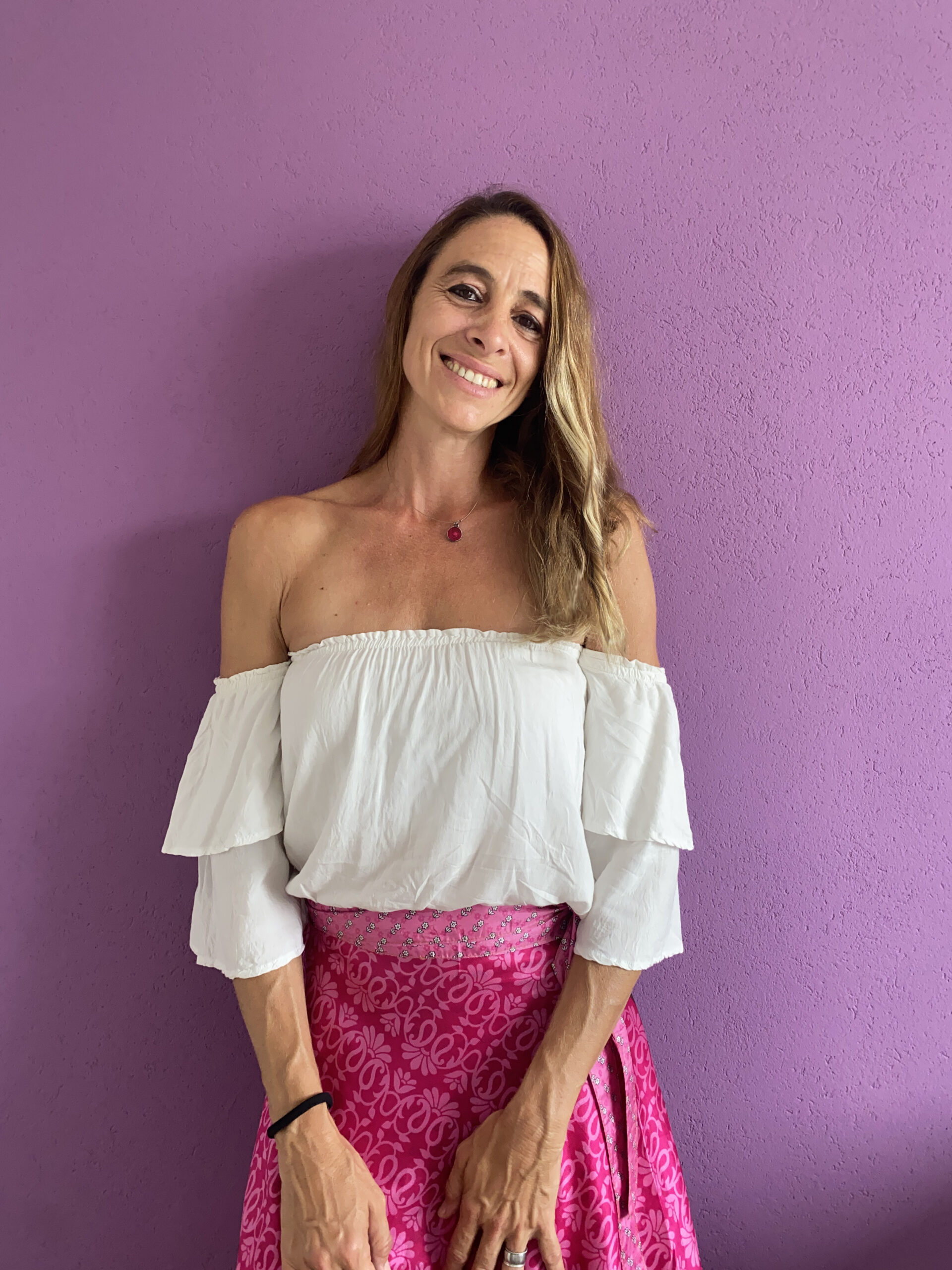 Foto de presentación de Laura con fondo fucsia remera blanca y pollera rosa